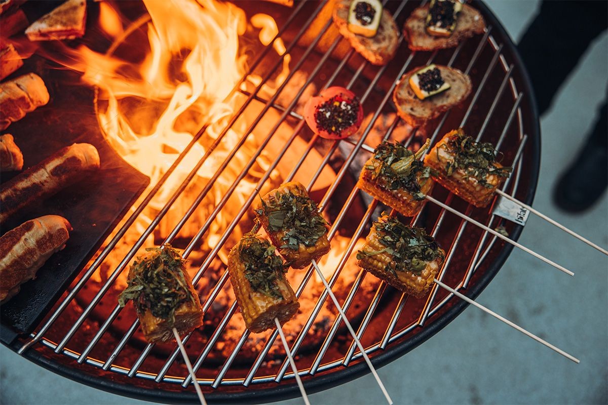 Grilled food on skewers over a fire pit