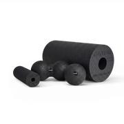 Black textured foam massage tools including a large cylindrical roller, a smaller cylindrical roller, and three spherical balls, arranged on a clean white background.