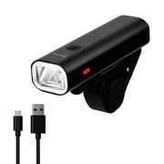 A black BRVIGA bicycle headlight with a USB charging cable shown below it on a plain white background. The headlight has a clear front lens, a small red indicator light, and the brand logo 'BRVIGA' is visible in the top left corner.