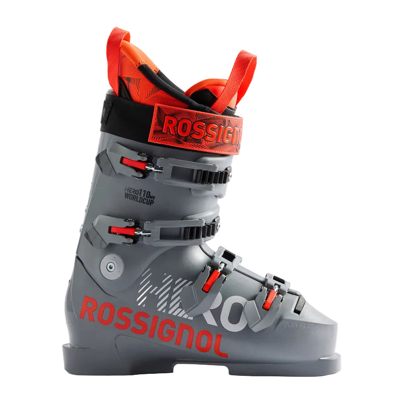 A Rossignol ski boot in gray with bright orange-red accents and black buckles, shown from a side profile on a light gray studio background.