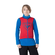 Person wearing a red and blue jacket with a logo on a white background