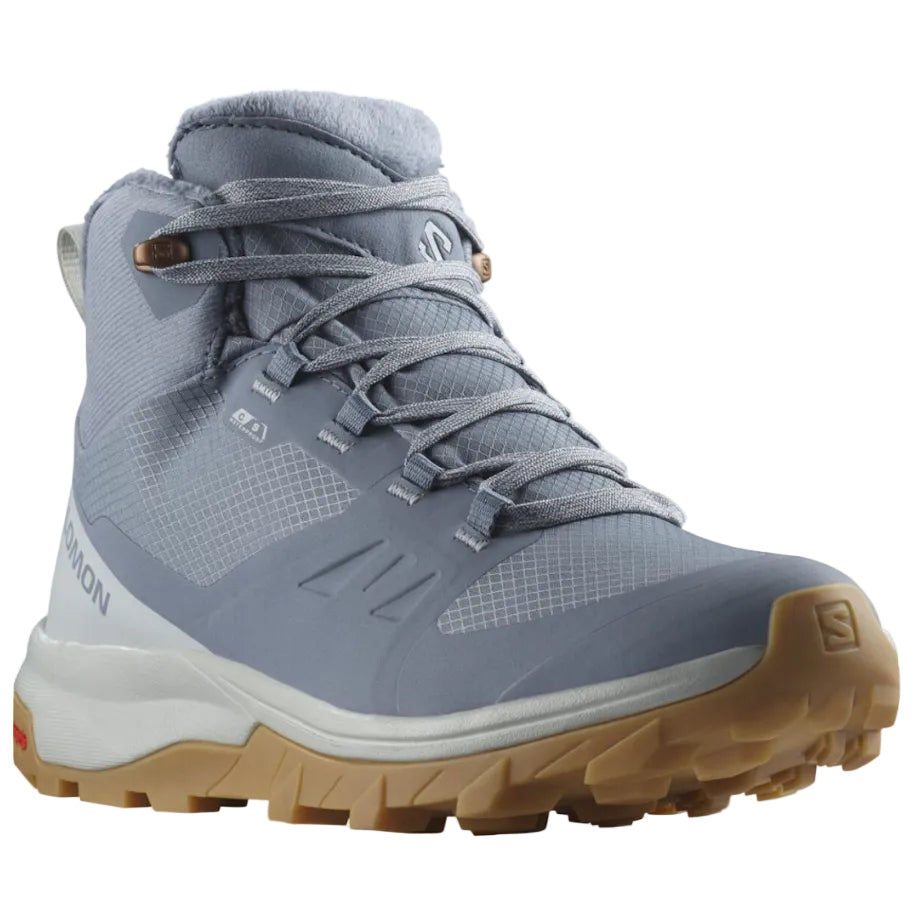 A Salomon mid-cut hiking boot in a muted slate blue-gray color, featuring a white midsole and a tan/gum outsole, shown against a plain white background.