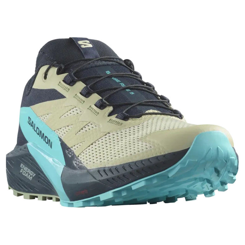 Salomon trail running shoe in beige, navy, and turquoise, shown from a side profile on a white background.