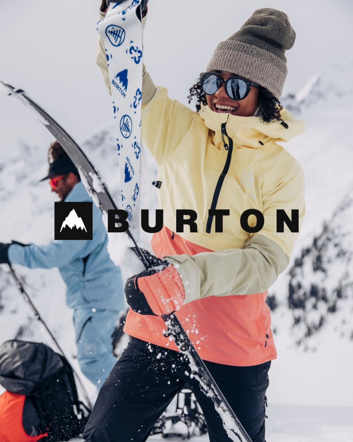 Person in winter gear with skis and Burton logo in a snowy setting