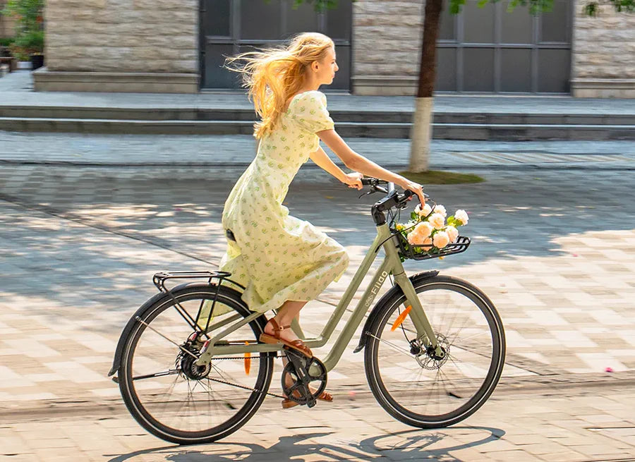Woman riding city bike with basket in urban street comfortable commuter bicycle lifestyle cycling
