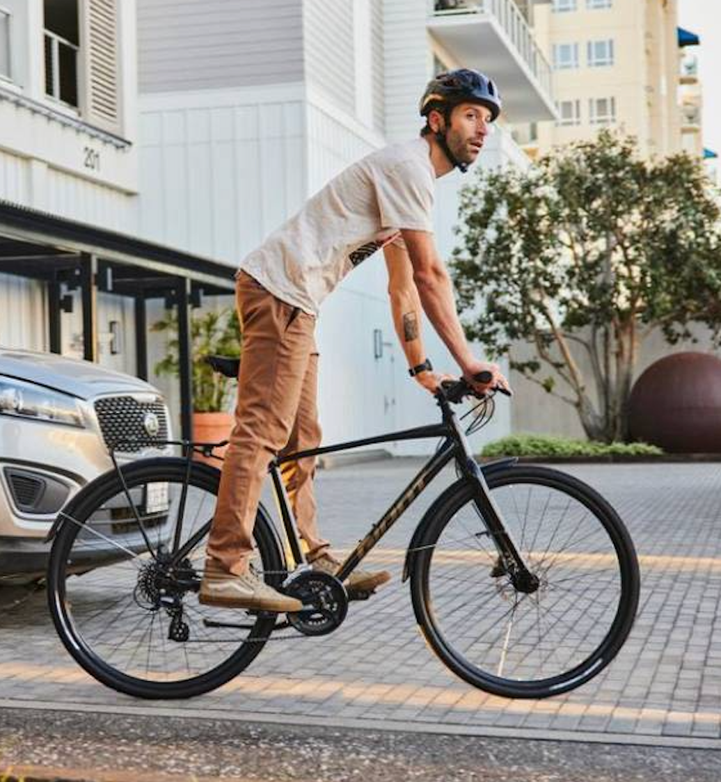 Man riding commuter bike in city wearing helmet urban cycling daily transport bicycle