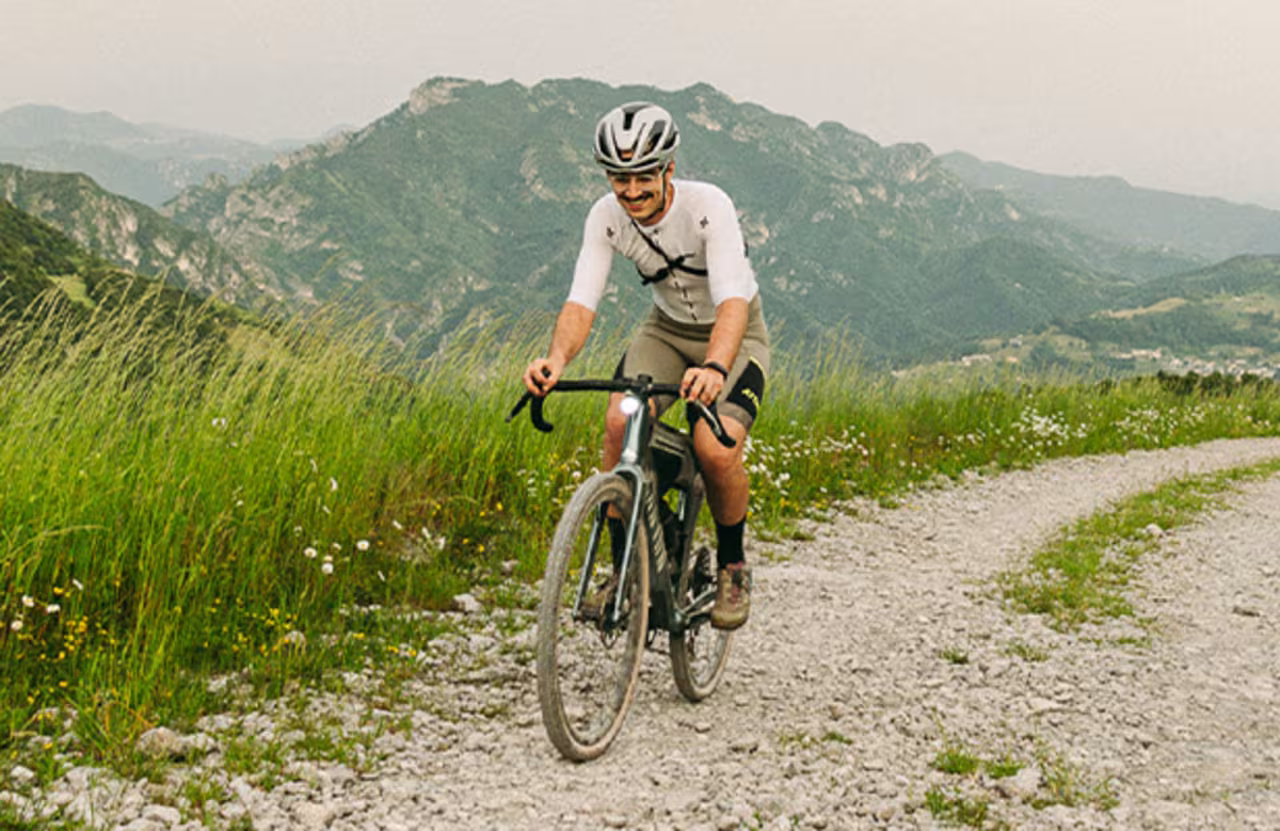 Man riding gravel bike on mountain trail wearing cycling helmet outdoor gravel cycling ride