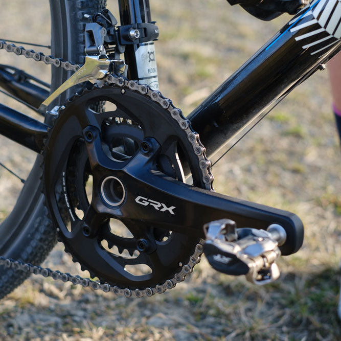 Close-up of a bicycle's gear system with 'GRX' branding on a blurred background.