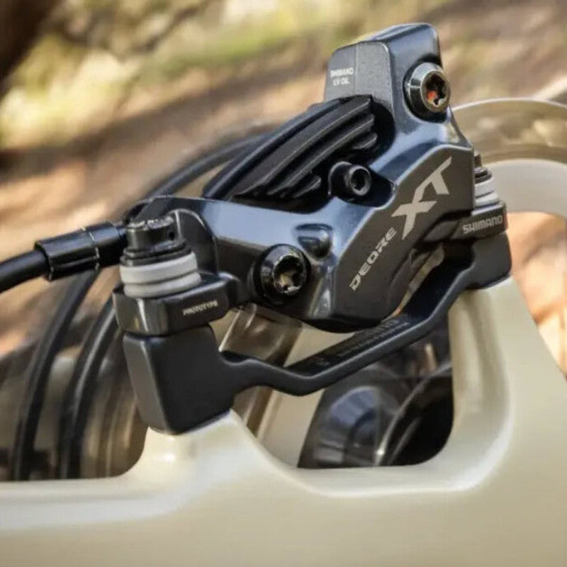 Close-up of a Shimano Deore XT brake lever on a blurred natural background